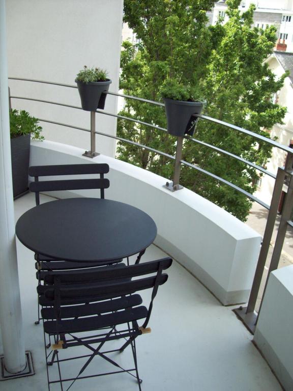 d'une table et de chaises sur un balcon orné de plantes. dans l'établissement T2 avec box proche Graslin, à Nantes