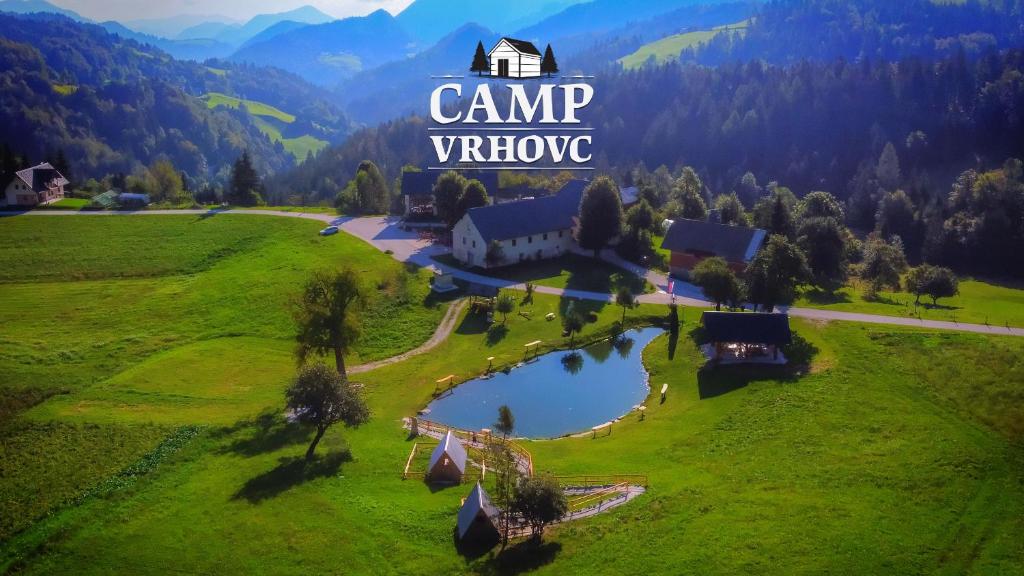 an aerial view of a farm with a house and a lake at Glamping Vrhovc in Železniki