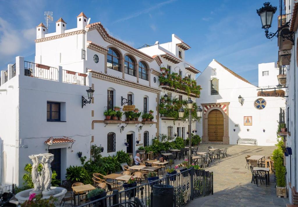 a building with tables and chairs in front of it at Posada La Plaza in Canillas de Albaida