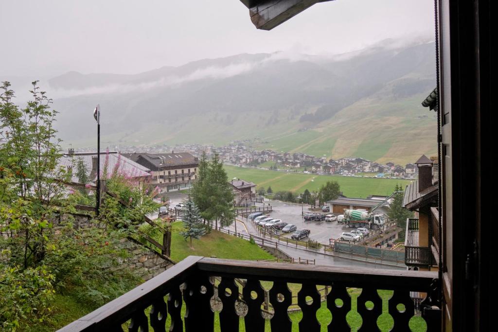 een balkon met uitzicht op een stad met bergen bij Teola in Livigno