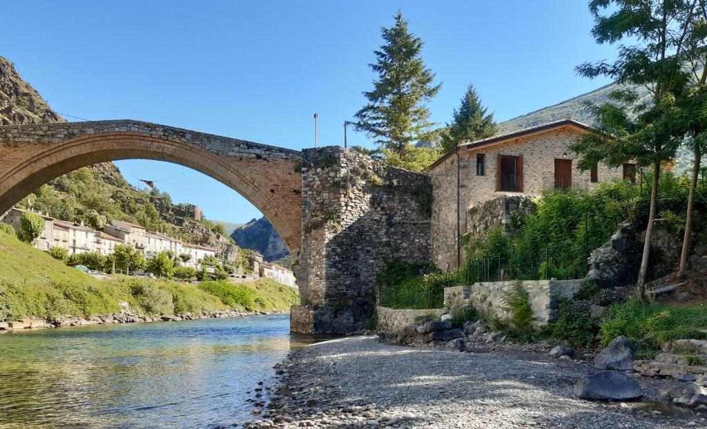 un viejo puente de piedra sobre un río con edificios en Casa del Pont, en Gerri