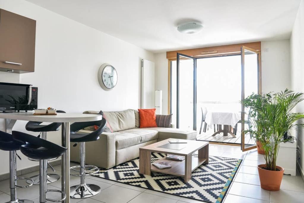 ein Wohnzimmer mit einem Sofa und einem Tisch in der Unterkunft Appartement l'Opale - T2 48m avec parking à 300m du Lac d'Annecy in Annecy
