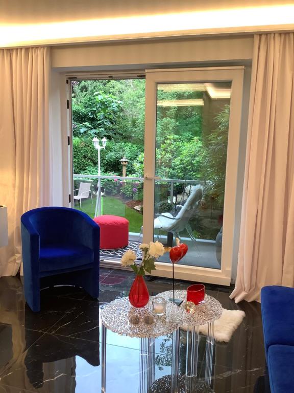 a living room with a glass table and blue chairs at LOFT4YOU Work & Stay, HOME OFFICE, W-LAN in Neuss