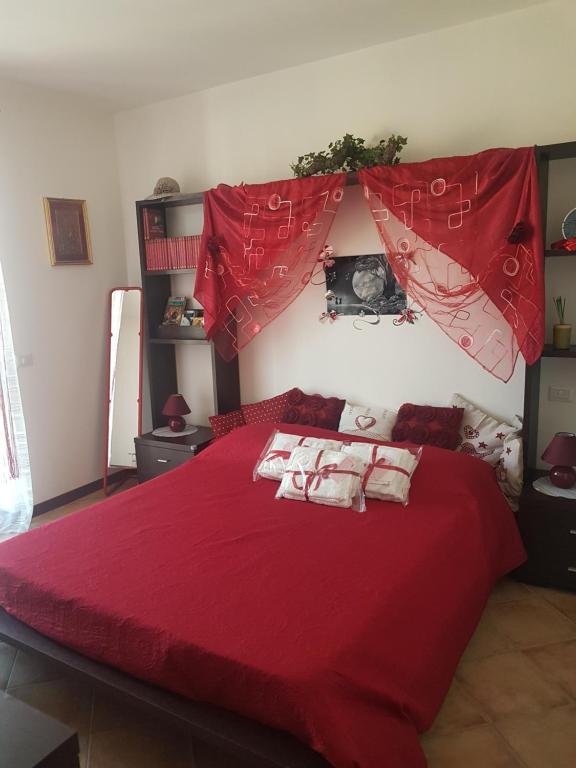 una camera con un letto rosso con due cuscini sopra di Barbara Meniconi a Città della Pieve