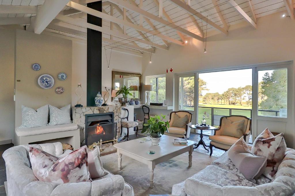 a living room with couches and a fireplace at Hermanus Lodge on the Green - Solar Power in Hermanus