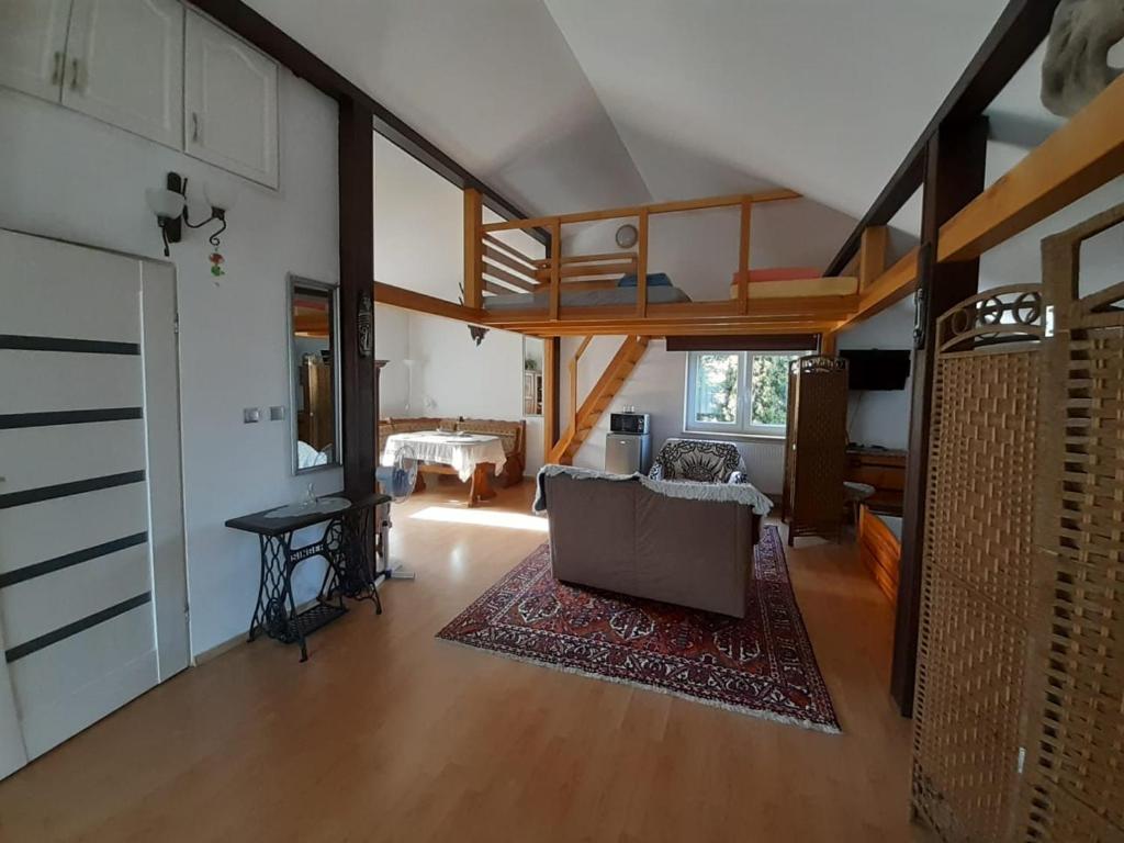 uma sala de estar com um sofá e um loft em Apart - House em Sandomierz