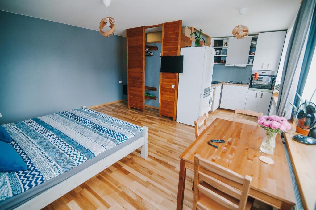 a bedroom with a bed and a table and a kitchen at City center Appartment in Valmiera