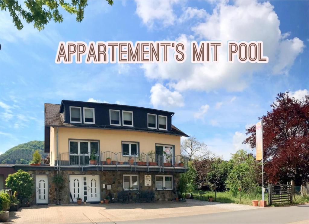 a building with the words applicants mitt pool on top of it at Residenz Moselzauber - Ferienwohnungen mit Pool Landschaft in Ernst