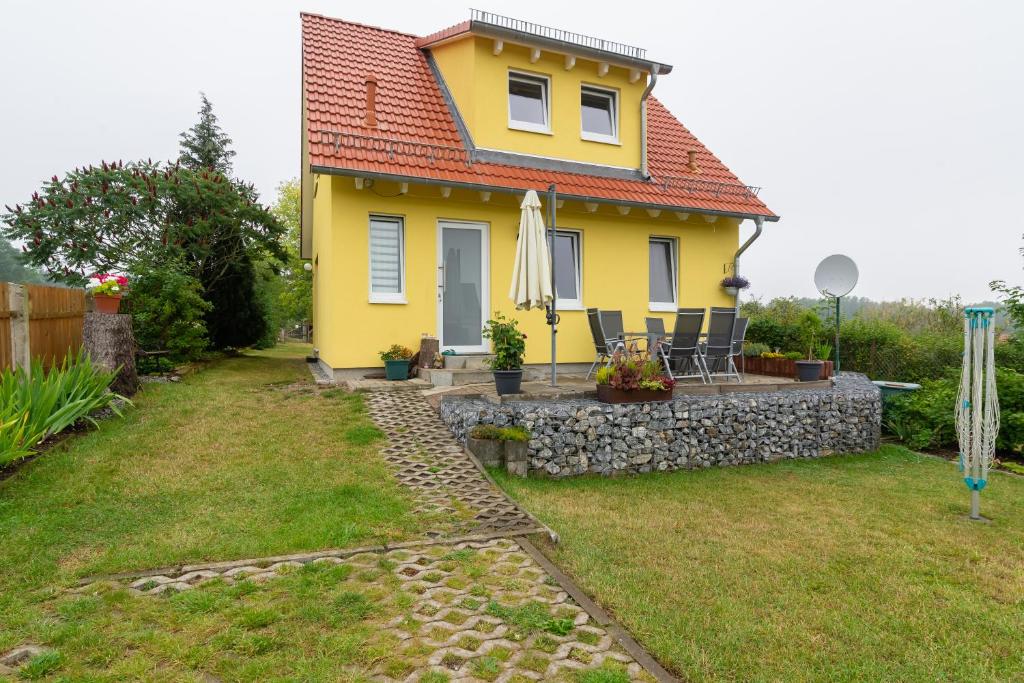 une maison jaune avec un mur en pierre dans l'établissement Ferienhaus Natzel, à Darlingerode