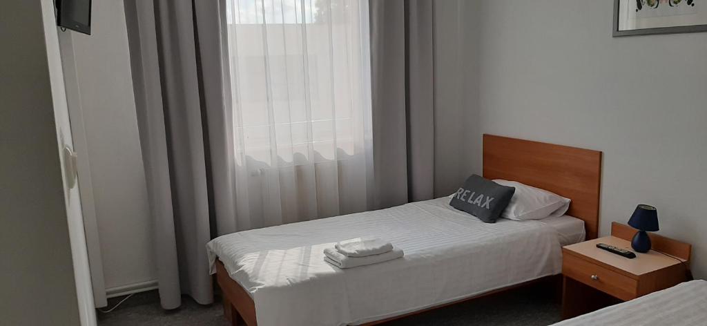a small bedroom with a bed and a window at Hotel U Zygmuntów in Leżajsk
