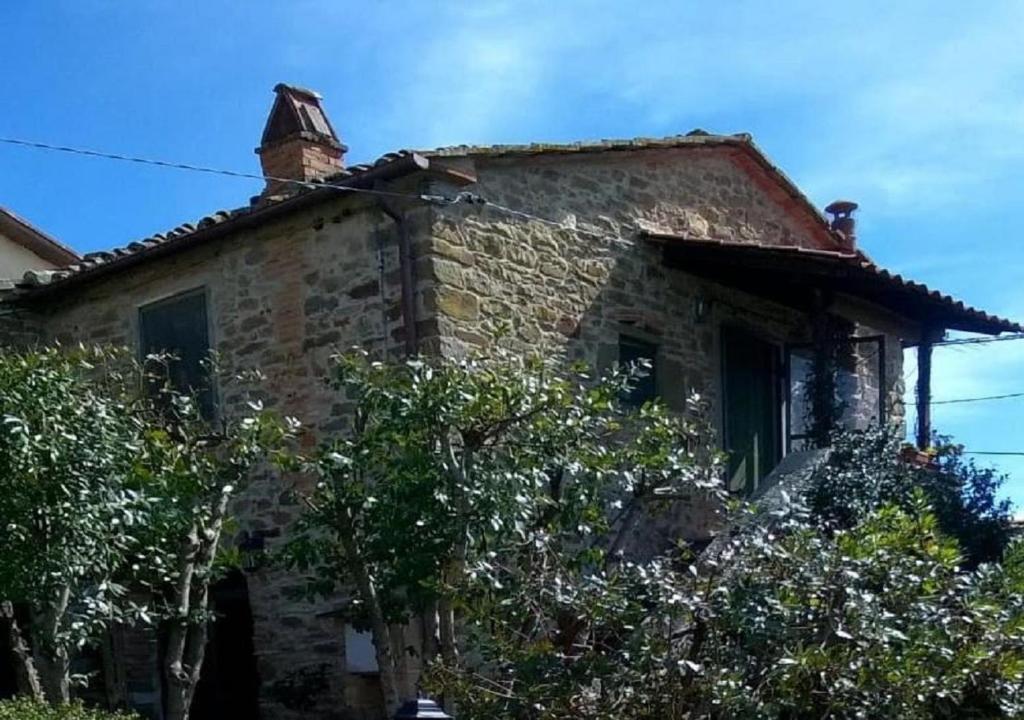 an old stone house with a chimney on top of it at La Cuccia - La Villa-San Pacrazio in Ambra