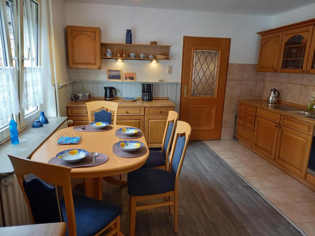 a kitchen with a wooden table and chairs and a table and chairsktop at Geräumige Ferienwohnung in Felsberg in Felsberg