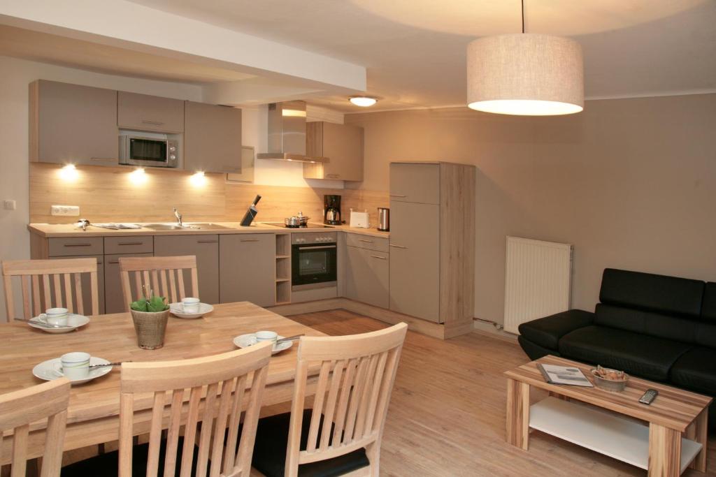 een keuken en een woonkamer met een tafel en een bank bij Relaxappartement Wymbs in Zell am See