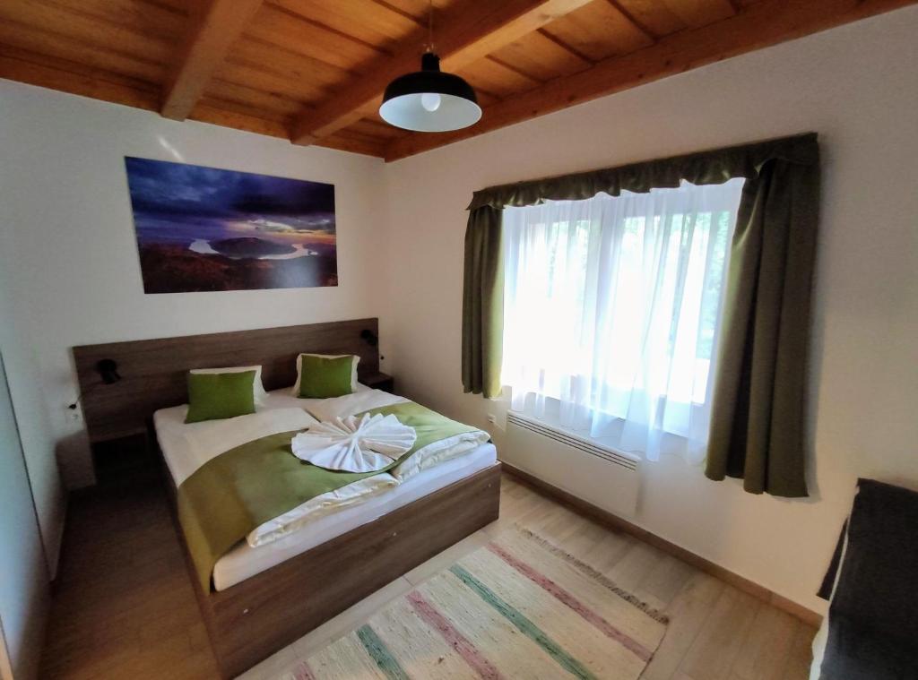 Schlafzimmer mit einem Bett und einem Fenster in der Unterkunft Kishíd Vendégház Pilismarót in Pilismarót