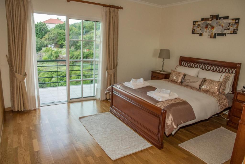 um quarto com uma cama e uma grande janela em ZiZis Place em Santa Cruz - Madeira