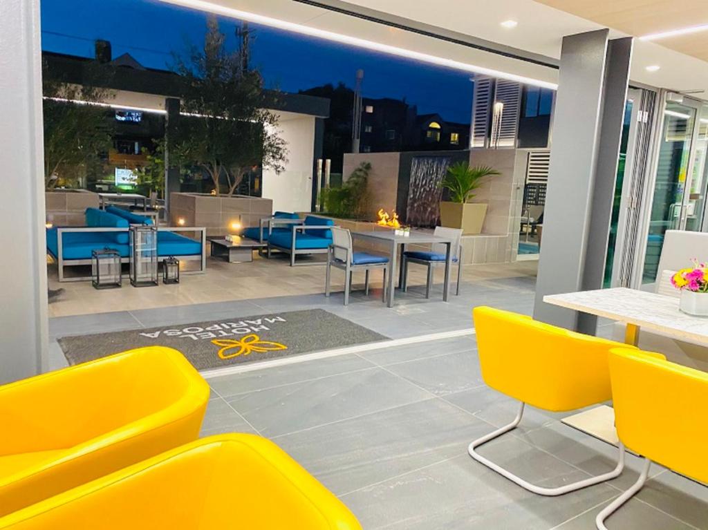um pátio com cadeiras e mesas amarelas num edifício em Hotel Mariposa em Los Angeles