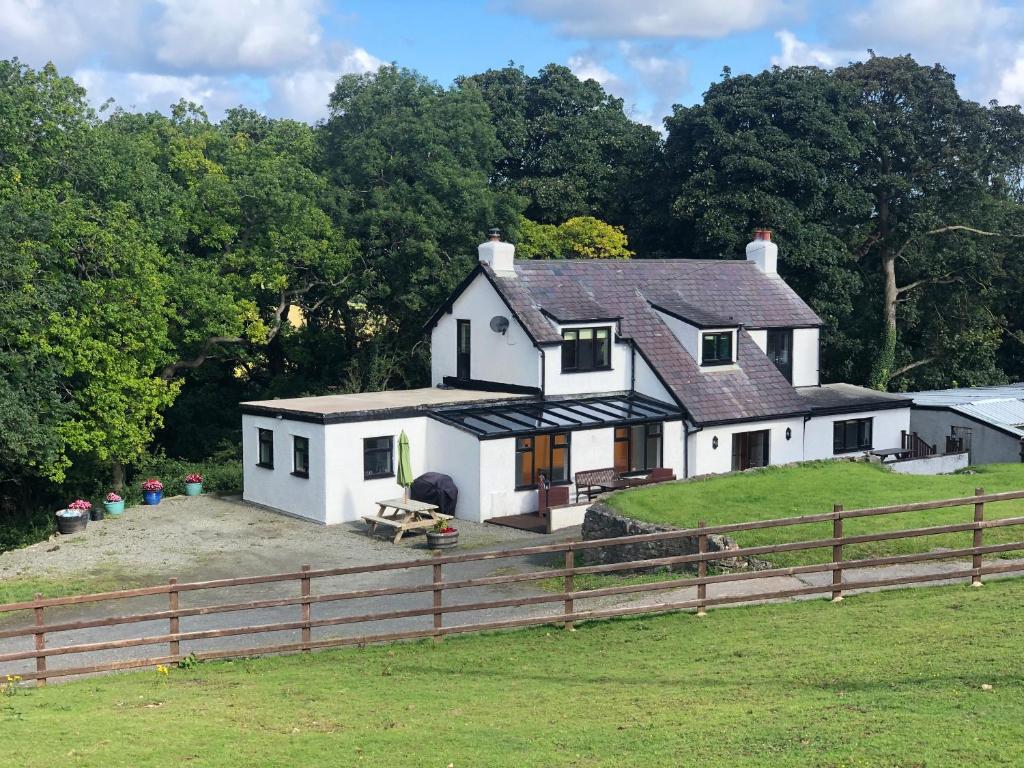una casa blanca con una valla delante en Cae Cwnws en Conwy