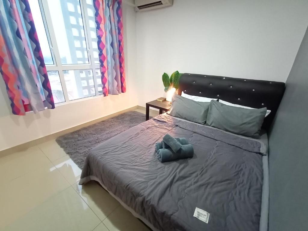 ein Schlafzimmer mit einem Bett mit einem blauen Teddybär darauf in der Unterkunft Homi Homestay Menara U2 in Shah Alam