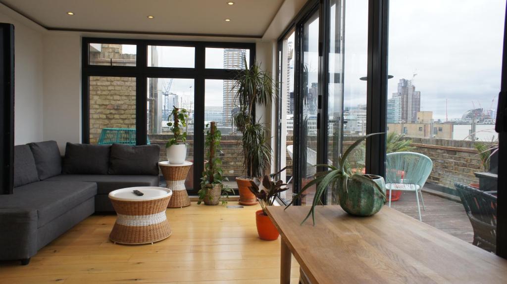 a living room with a couch and large windows at Shoreditch Place in London