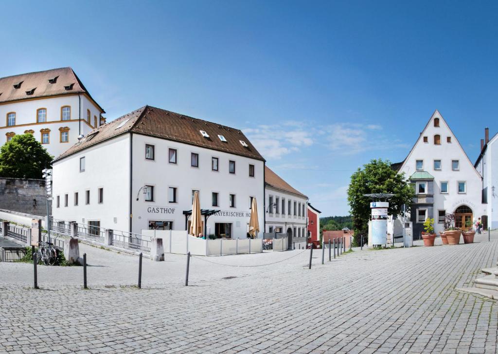 a cobblestone street in a town with white buildings at Hotelgasthof Bayerischer Hof in Sulzbach-Rosenberg