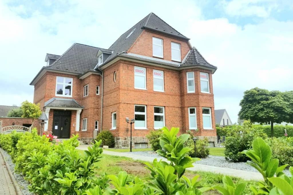 ein großes rotes Backsteinhaus mit schwarzem Dach in der Unterkunft Villa Pries in Kiel