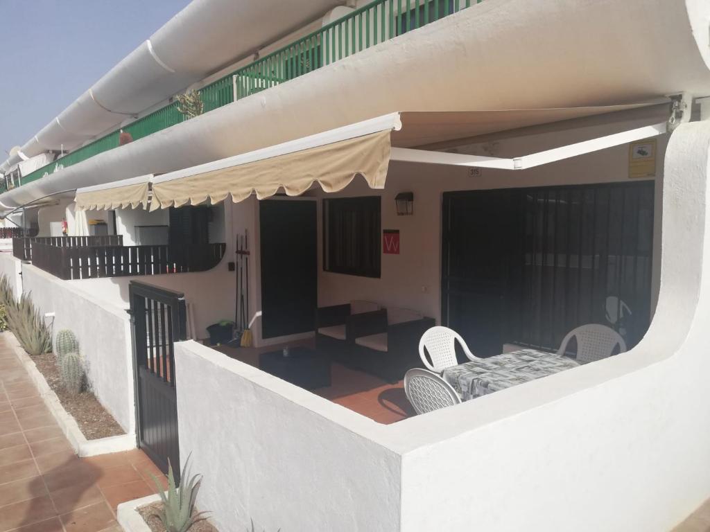 un balcón de una casa con sillas y toldo en Vandaele Home, en Corralejo