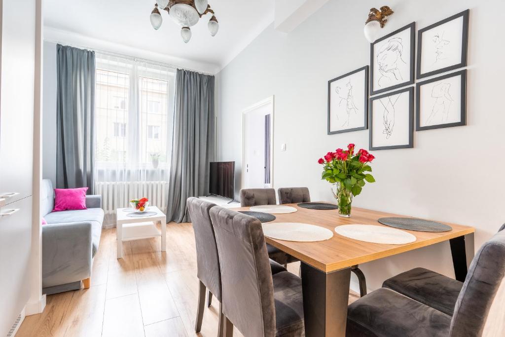 a dining room and living room with a table and chairs at Pod arkadami in Warsaw