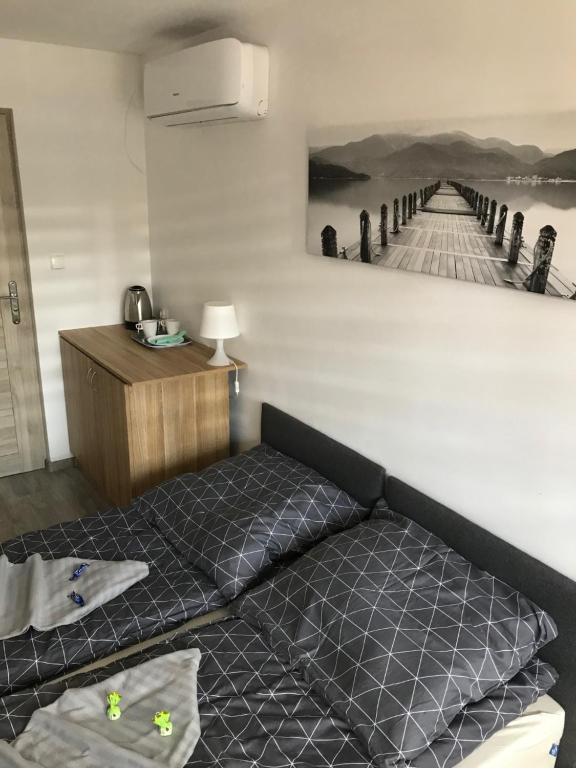 a bed in a room with a painting of a pier at Na Fali in Dziwnów
