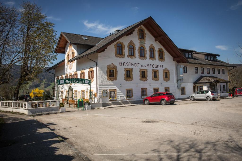 een gebouw met een rode auto ervoor geparkeerd bij Seewirt in Zell am Moos