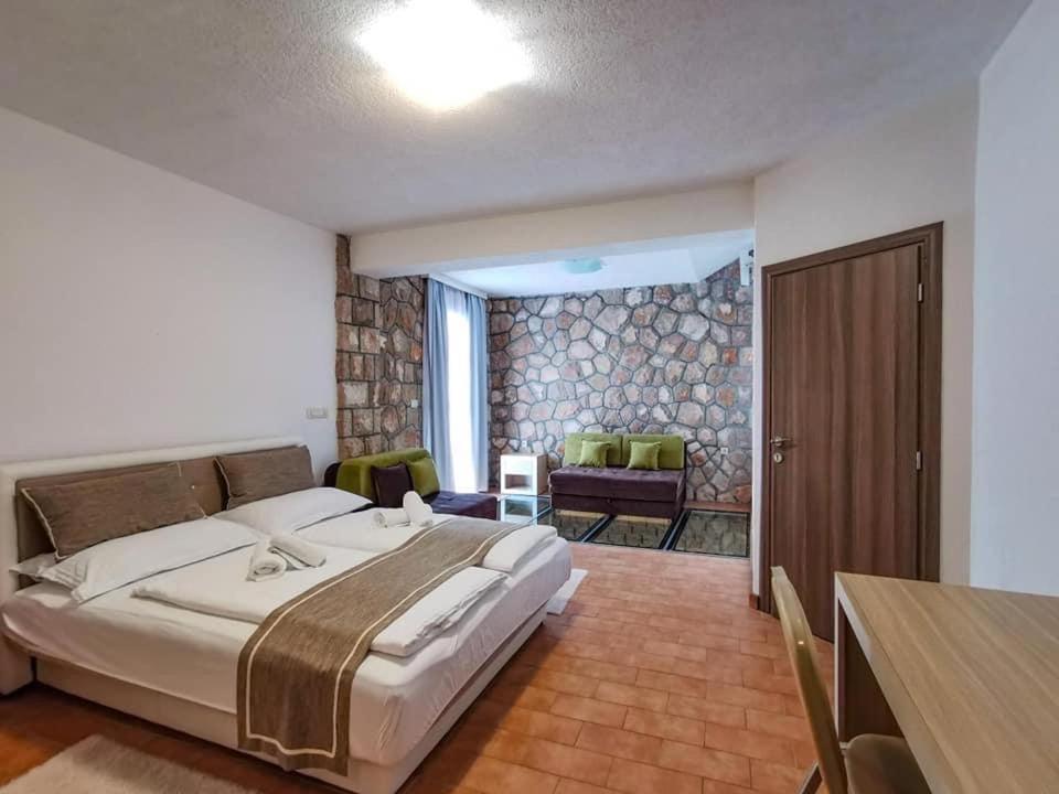 a bedroom with a large bed and a living room at Eco-selo Grabovica in Grabovica