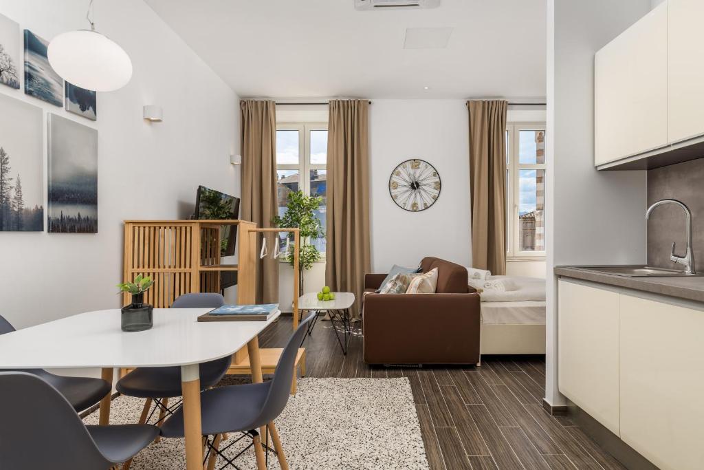 a kitchen and living room with a table and chairs at Apartments Harbour View in Rijeka