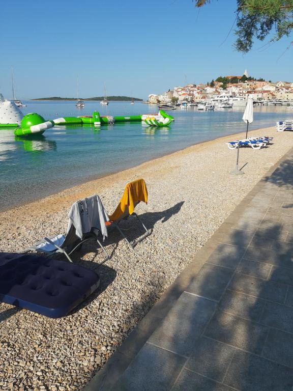 a beach with a mattress and chairs on the shore at Room-Delux- with a modern bathroom- - Primosten -Lokvice 6 in Primošten