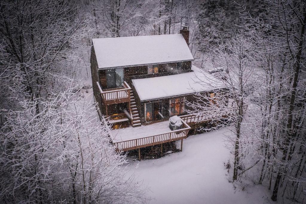 widok z góry na dom pokryty śniegiem w obiekcie Quaint Stowe Cabin w mieście Stowe