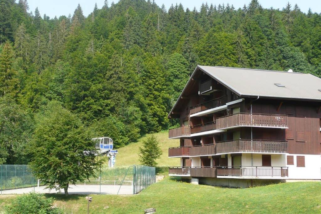 un edificio con un canestro da basket di fronte a una foresta di Les Chalets du Pounant - Alpes du Léman a Bellevaux