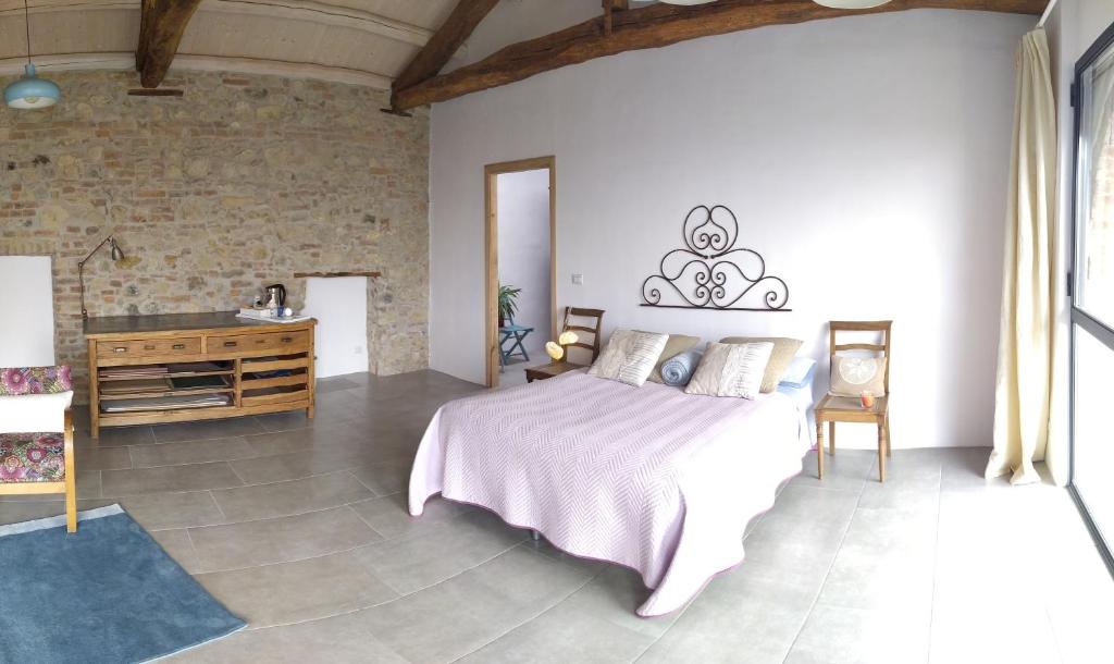 ein Schlafzimmer mit einem großen Bett und einer Steinmauer in der Unterkunft B&B The Wine Room - Az. Agr. Matunei in Cardona