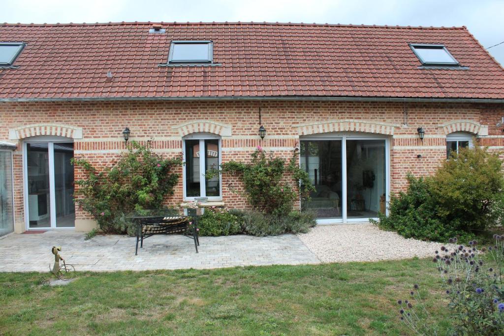 a brick house with a bench in front of it at Jolie maison 2 chambres - jardin in Le Hamel