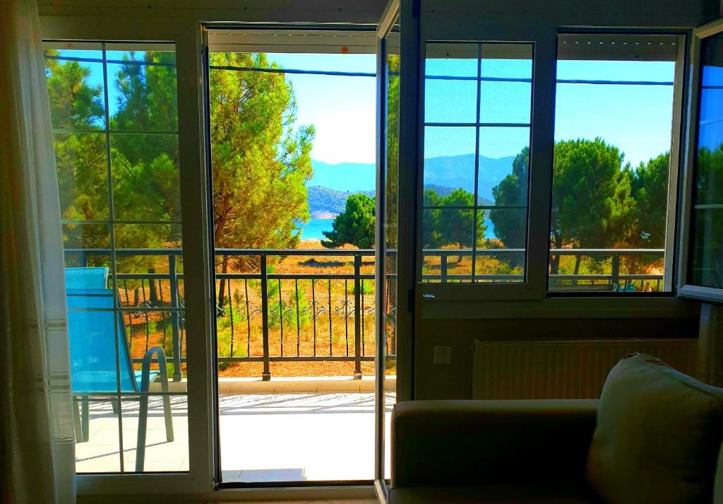 a living room with a door open to a balcony at Ourania luxury apartment in Keramotí