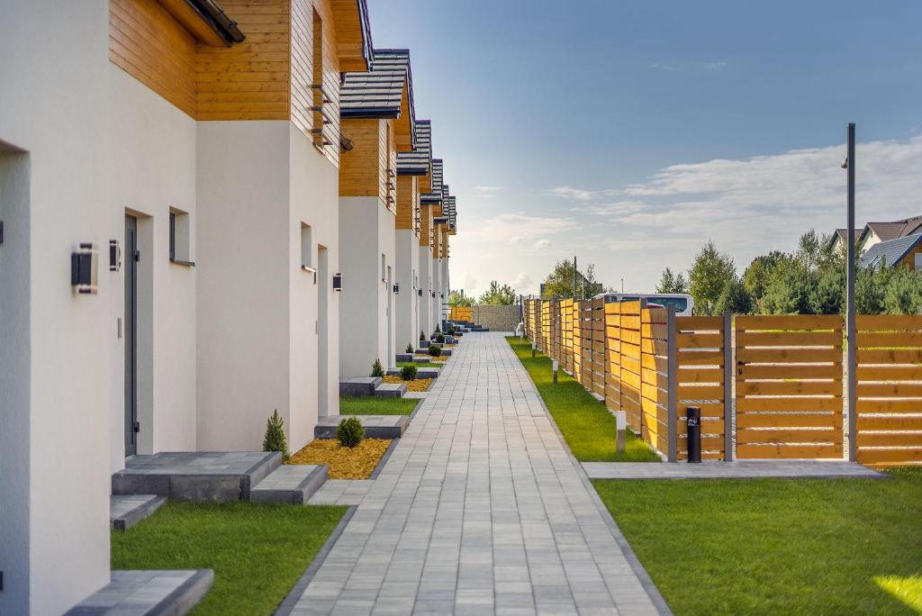 a walkway between two buildings with a fence at Domki Złote Piaski in Jastrzębia Góra