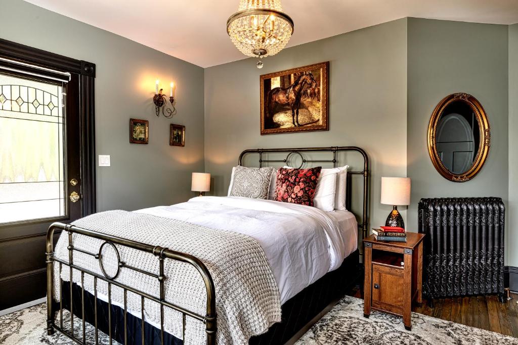 a bedroom with a large bed and a mirror at Slaymaker & Nichols Gastro House & Inn in Charlottetown