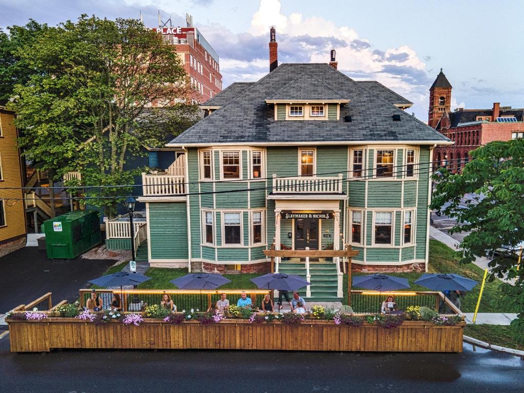 uma casa grande com guarda-chuvas em frente em Slaymaker & Nichols Gastro House & Inn em Charlottetown