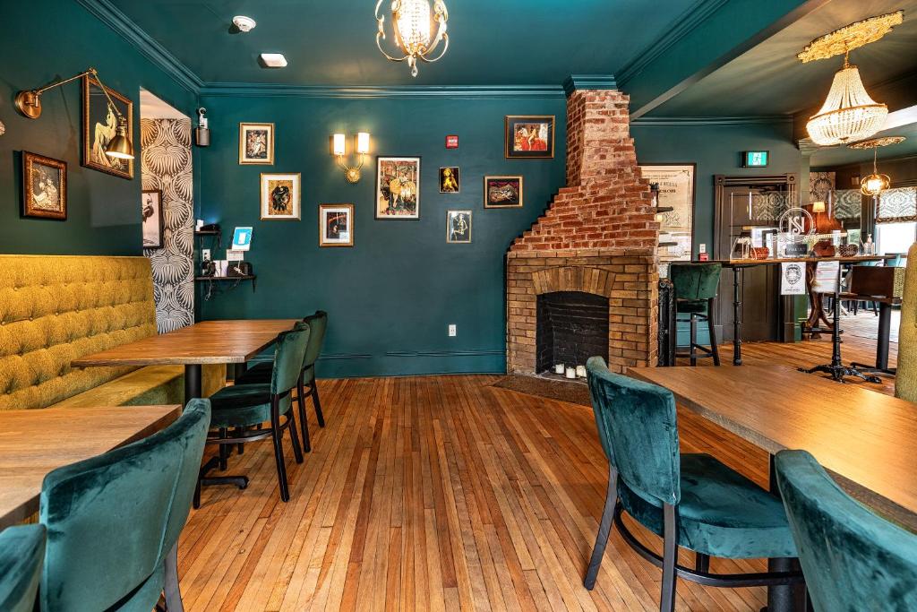 a dining room with wooden tables and a fireplace at Slaymaker & Nichols Gastro House & Inn in Charlottetown