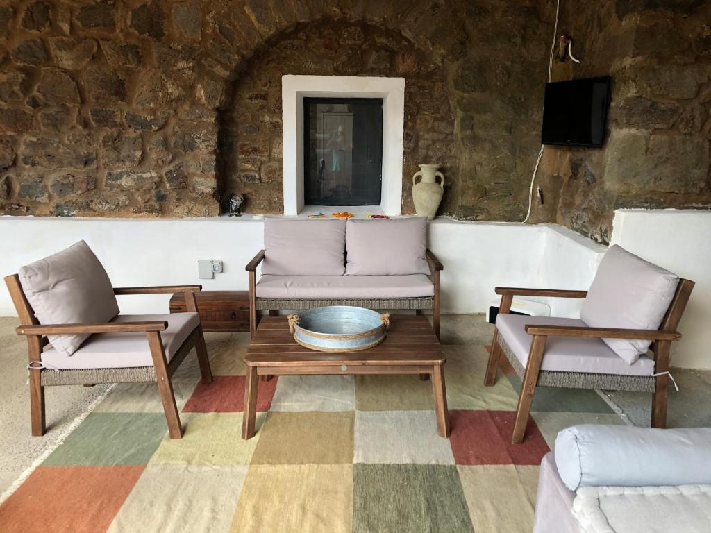 a living room with two chairs and a table at Dammuso Rekhale in Scauri