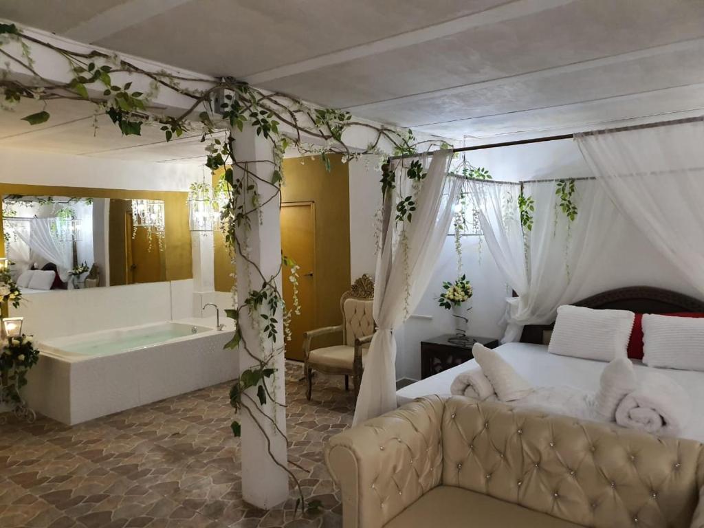 a bedroom with a bed and a bathtub and a bed and a bath tub at HOTEL BOUTIQUE EL FARO BY AROMAX in Medellín