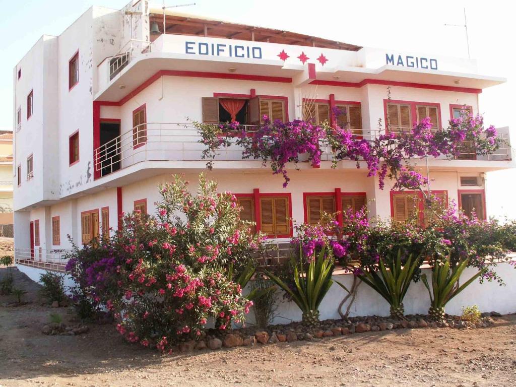 ein weißes Gebäude mit Blumen davor in der Unterkunft Edificio Magico in Tarrafal