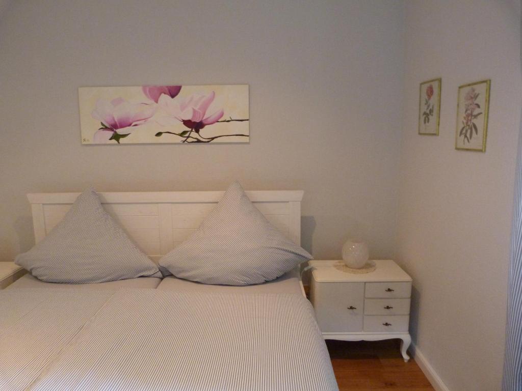 アーデナウにあるGästezimmer Am Hüstertのベッドルーム(白いベッド1台、ナイトスタンド付)