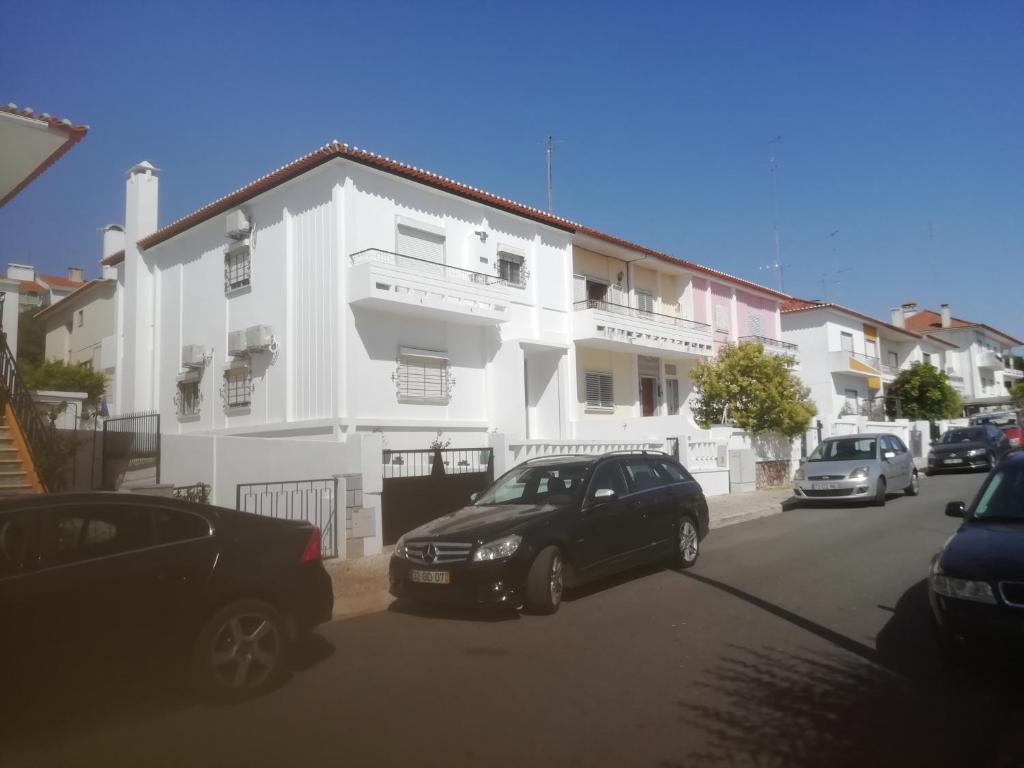 a black car parked in front of a white house at Casa do Jardim in Beja