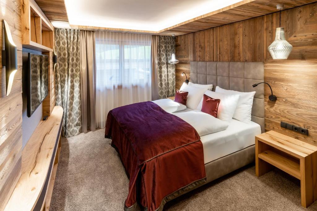 a hotel room with a bed and a television at Der Postwirt in Söll