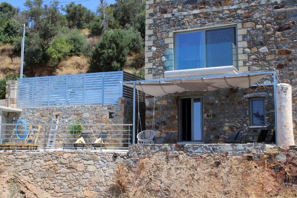 a stone house on a hill with a balcony at INO II Domus by Amigdalokefali Elafonissi in AmigdhalokeFálion