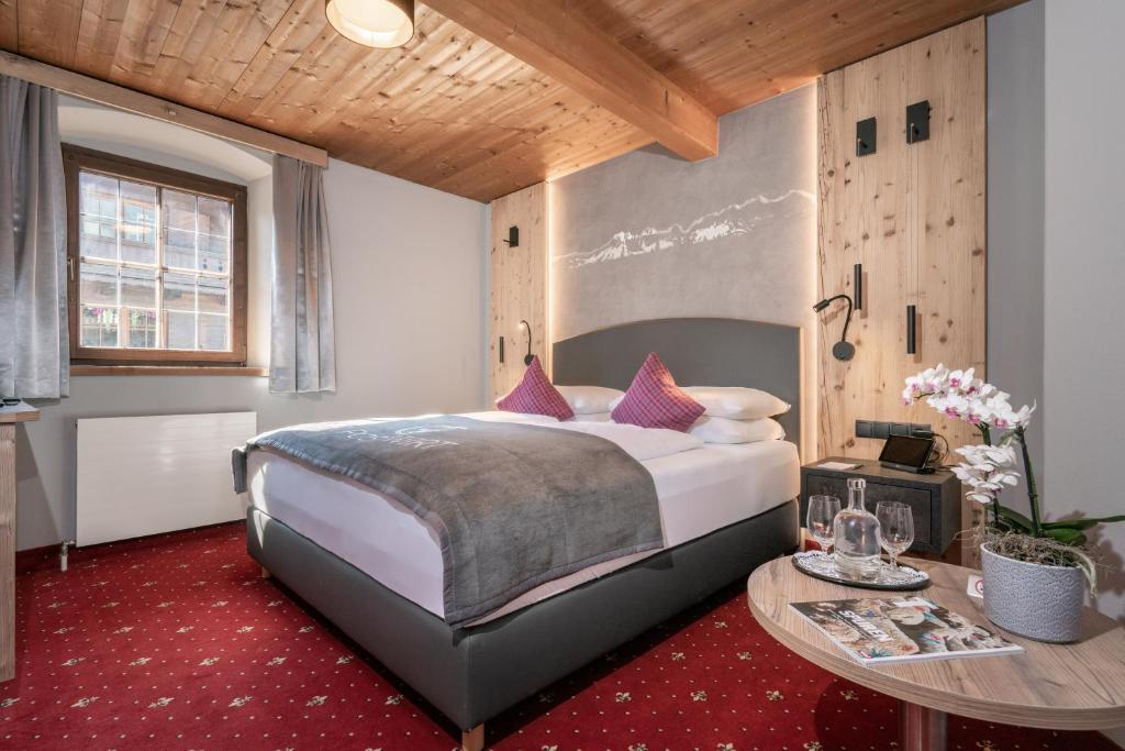 a bedroom with a large bed and a table at Der Postwirt in Söll