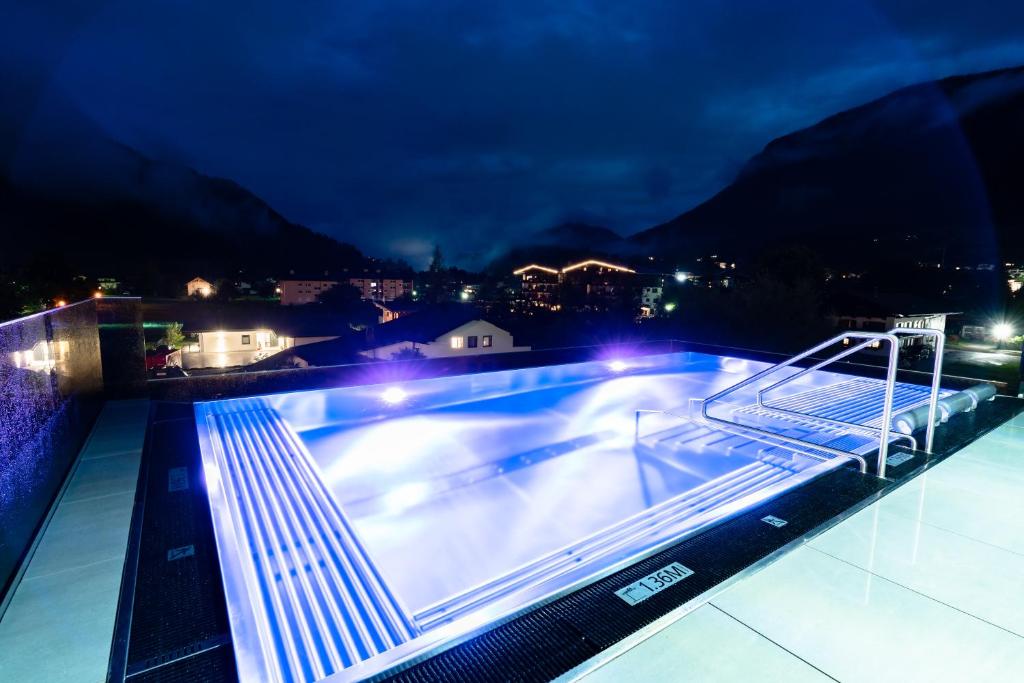 a swimming pool on top of a building at night at Der Postwirt in Söll